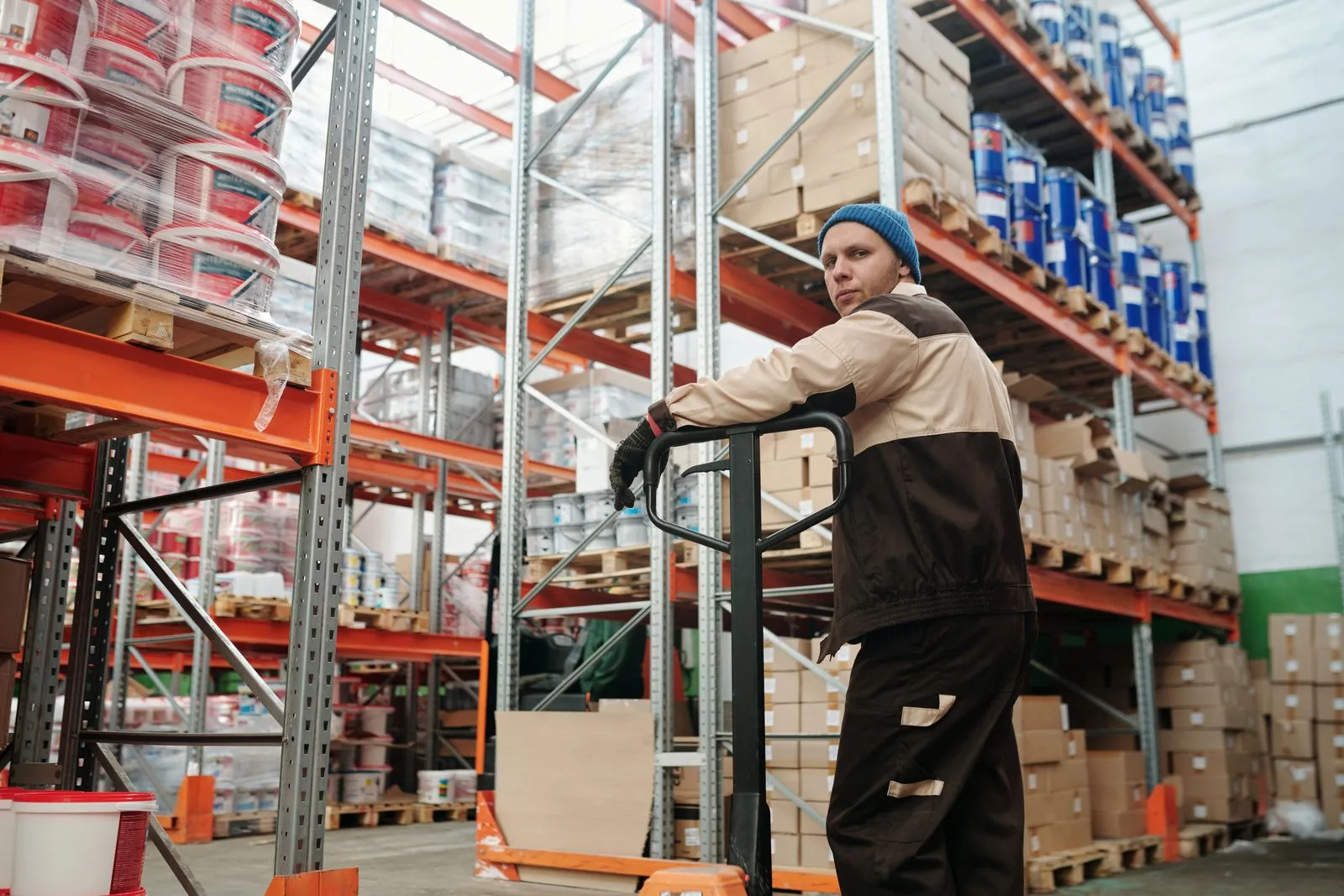 Warehouse worker moving cartons on a pallet jack